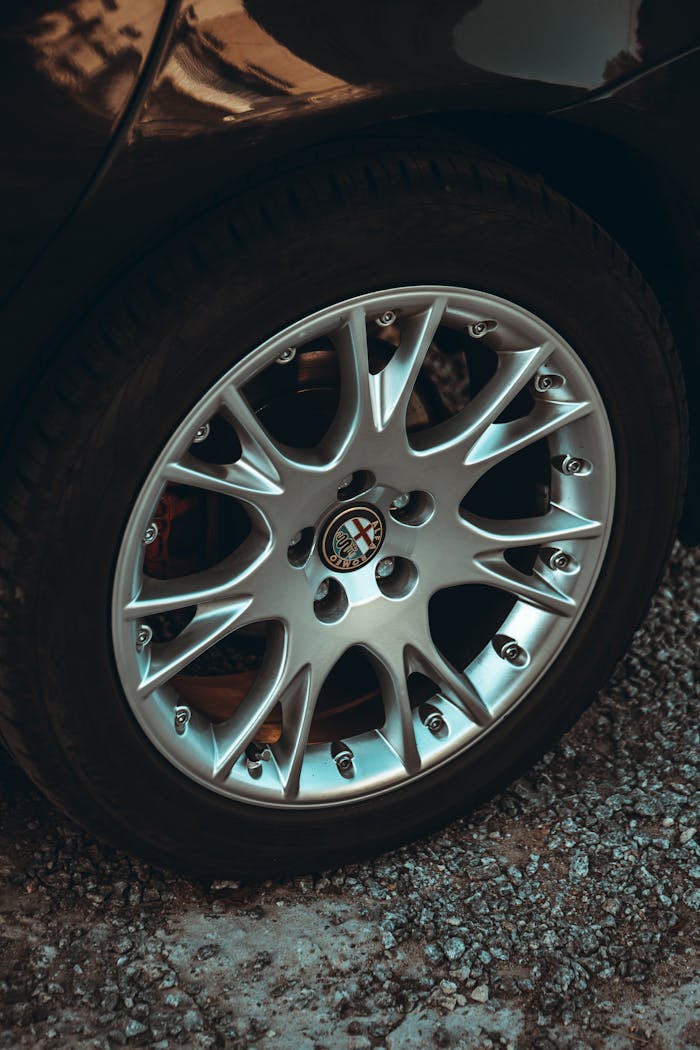 Detailed shot of a shiny alloy wheel on a vehicle, showcasing intricate design and metallic texture.